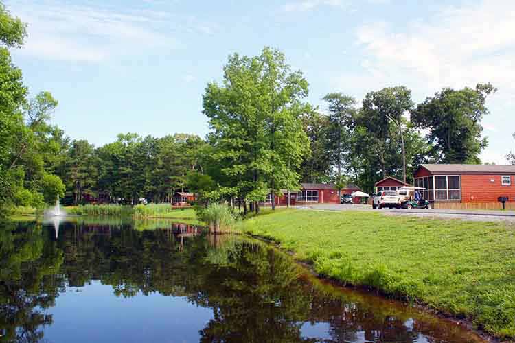 Fort Whaley RV Resort & Campground in Whaleyville, Maryland, with cabins along a pond.