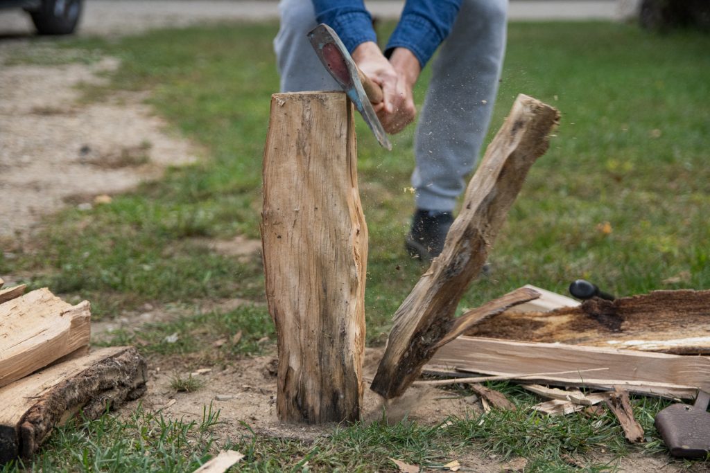 A man splits firewood with an axe.