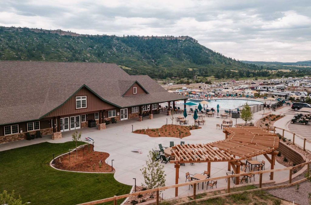 Welcome center with pool, RVs, and mountain in the back at Yogi Bear's Jellystone Park™ Camp-Resort: Larkspur in Larkspur, CO