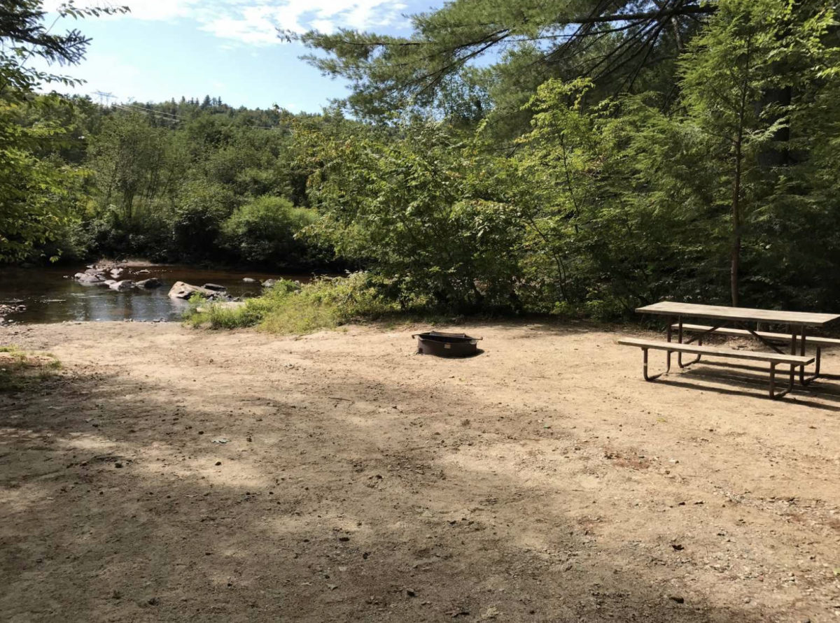 Campground on the river with fireplace and picnic table 