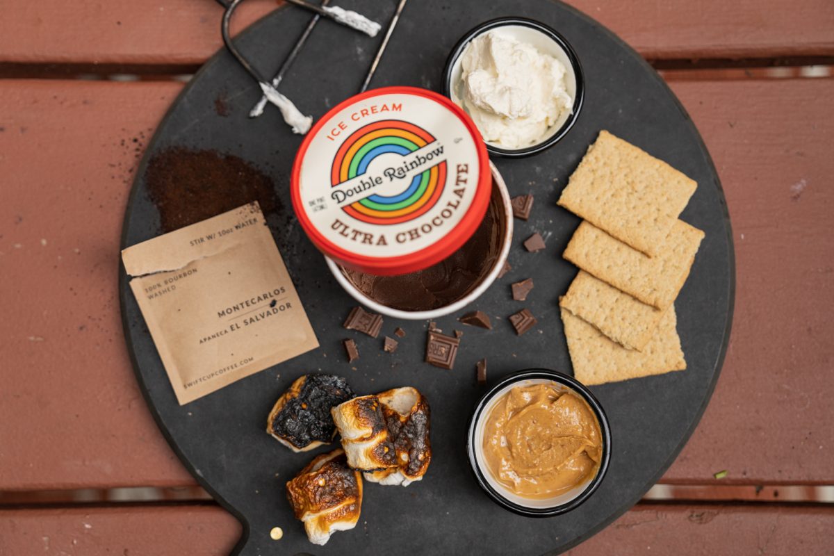 Ingredients for a s'more sundae include chocolate ice cream, graham crackers, peanut butter, roasted marshmallows, chocolate pieces, whipped cream, and instant coffee.