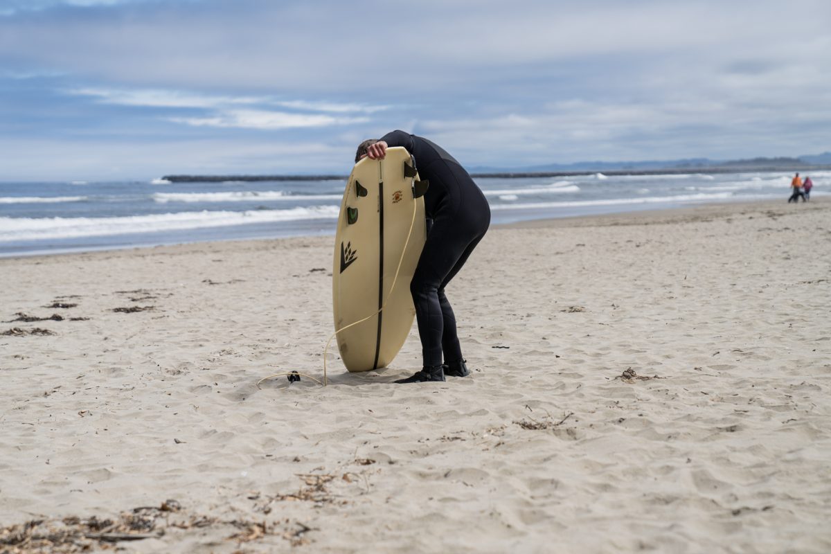A surfer waxes their board while going out to the Pacific Ocean from the Oceanside RV Resort and Campground in Coos Bay, Oregon.
