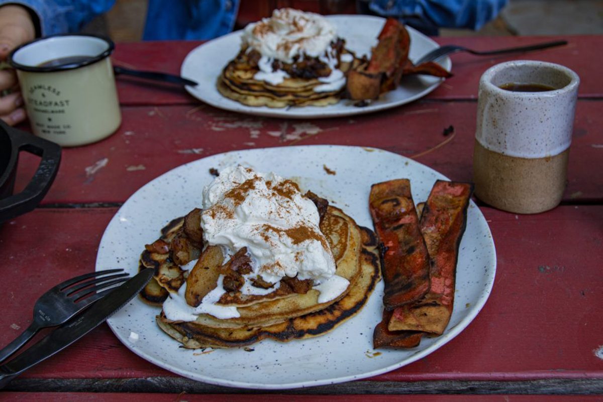 Apple bourbon pancakes with whipped topping, cinnamon, coffee, and veggie bacon. 