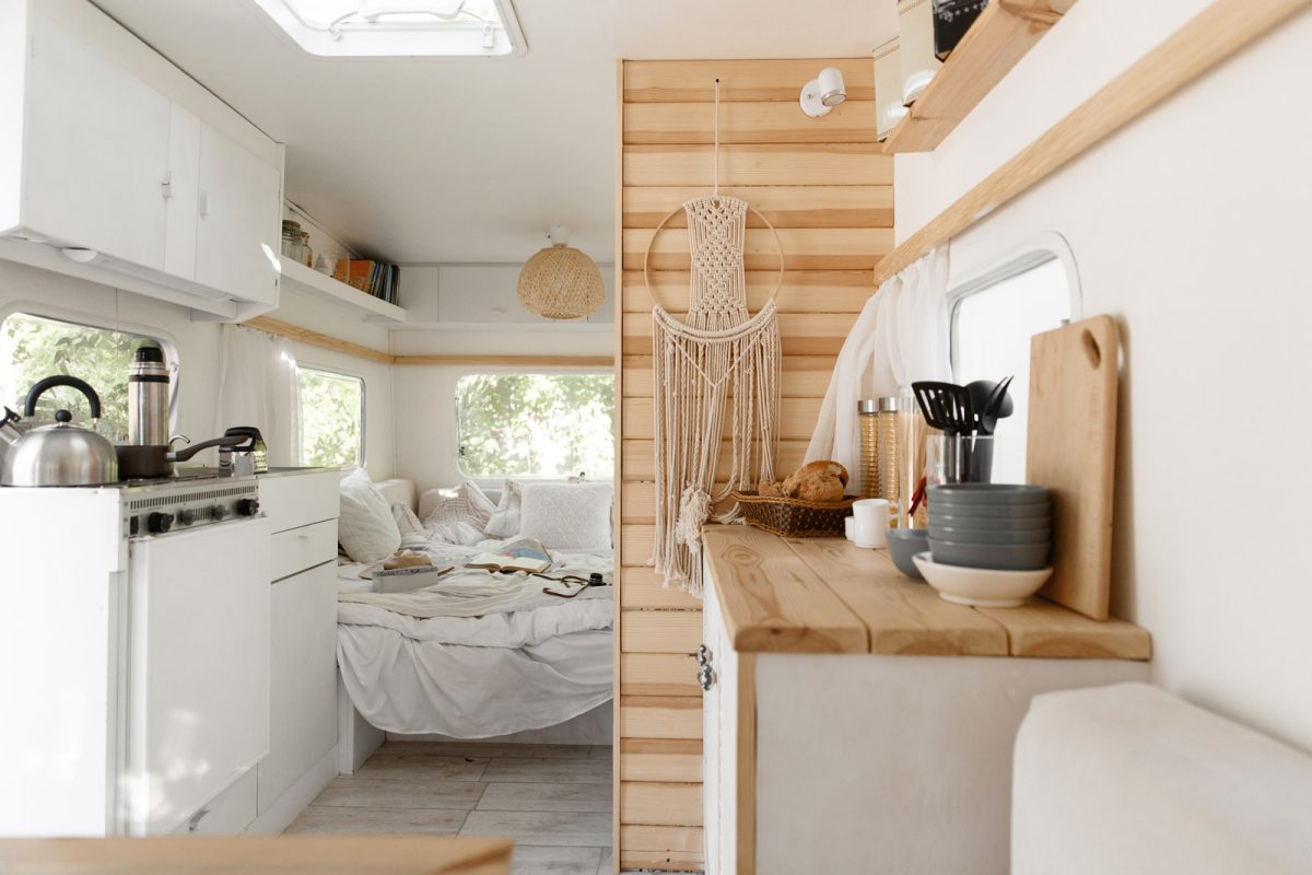 An RV kitchen and bedroom with with walls. 