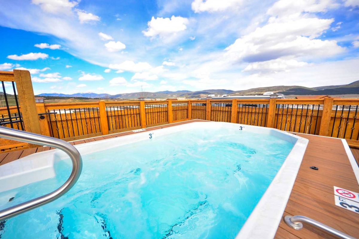 A hot tub on a deck with scenic mountain views in the distance. 