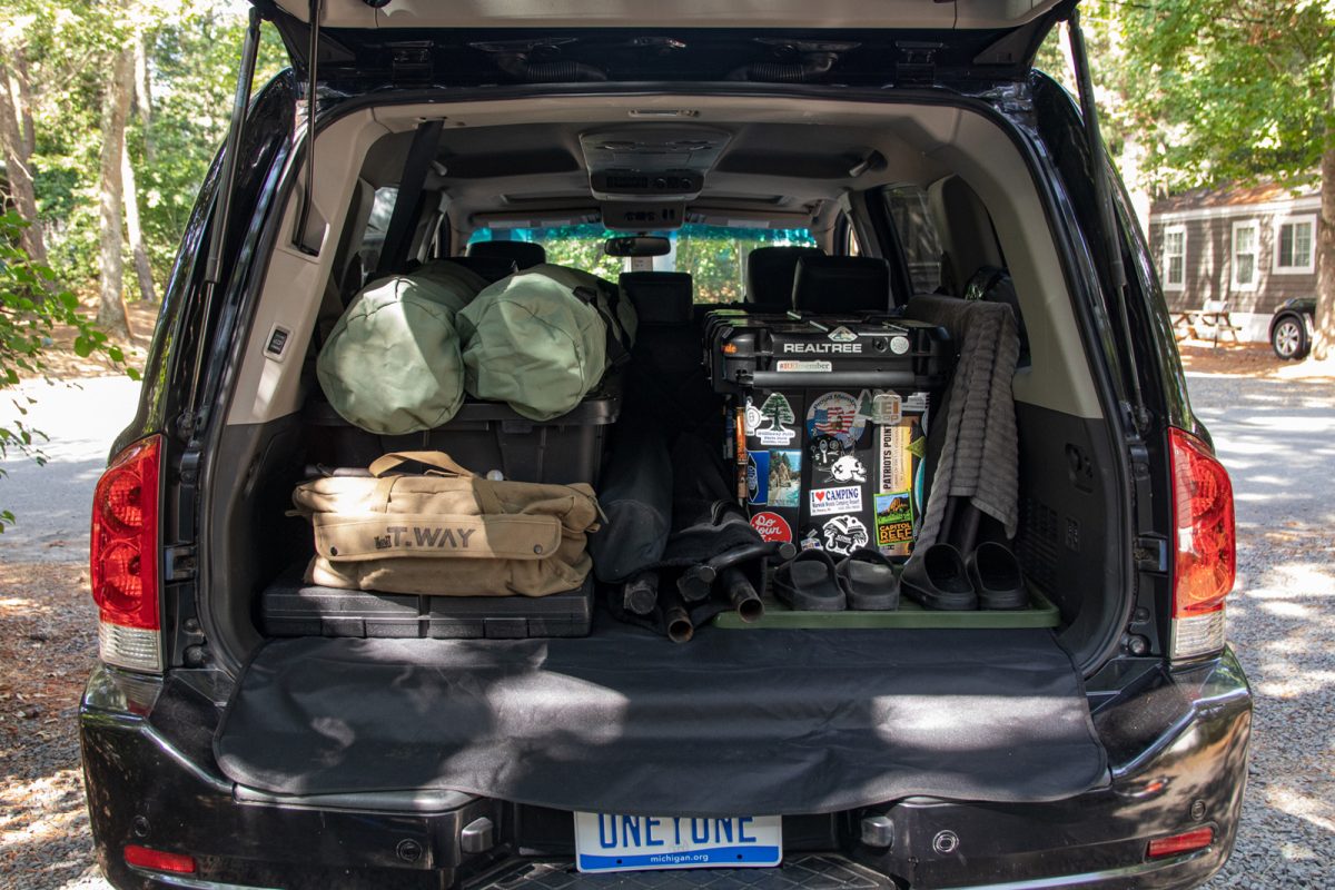 The interior of an SUV from the back view full of camping gear. 