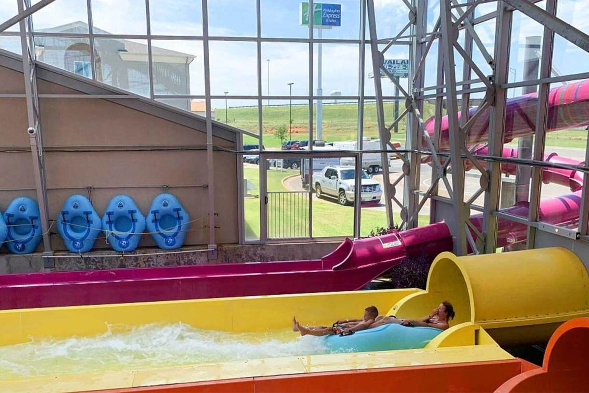 A woman and child exit a water slide in an indoor water park at Water-Zoo campground. 