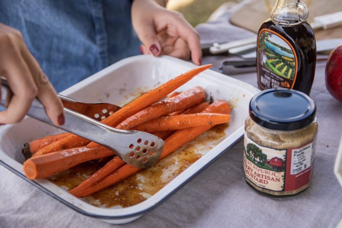 Tossing carrots in dijon and maple syrup for Thanksgiving camping recipes