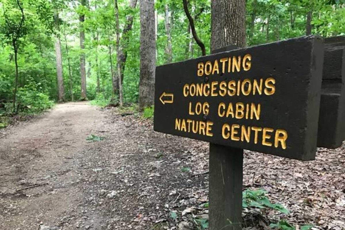 campground sign pointing down trail to boating, concessions, log cabin, nature center