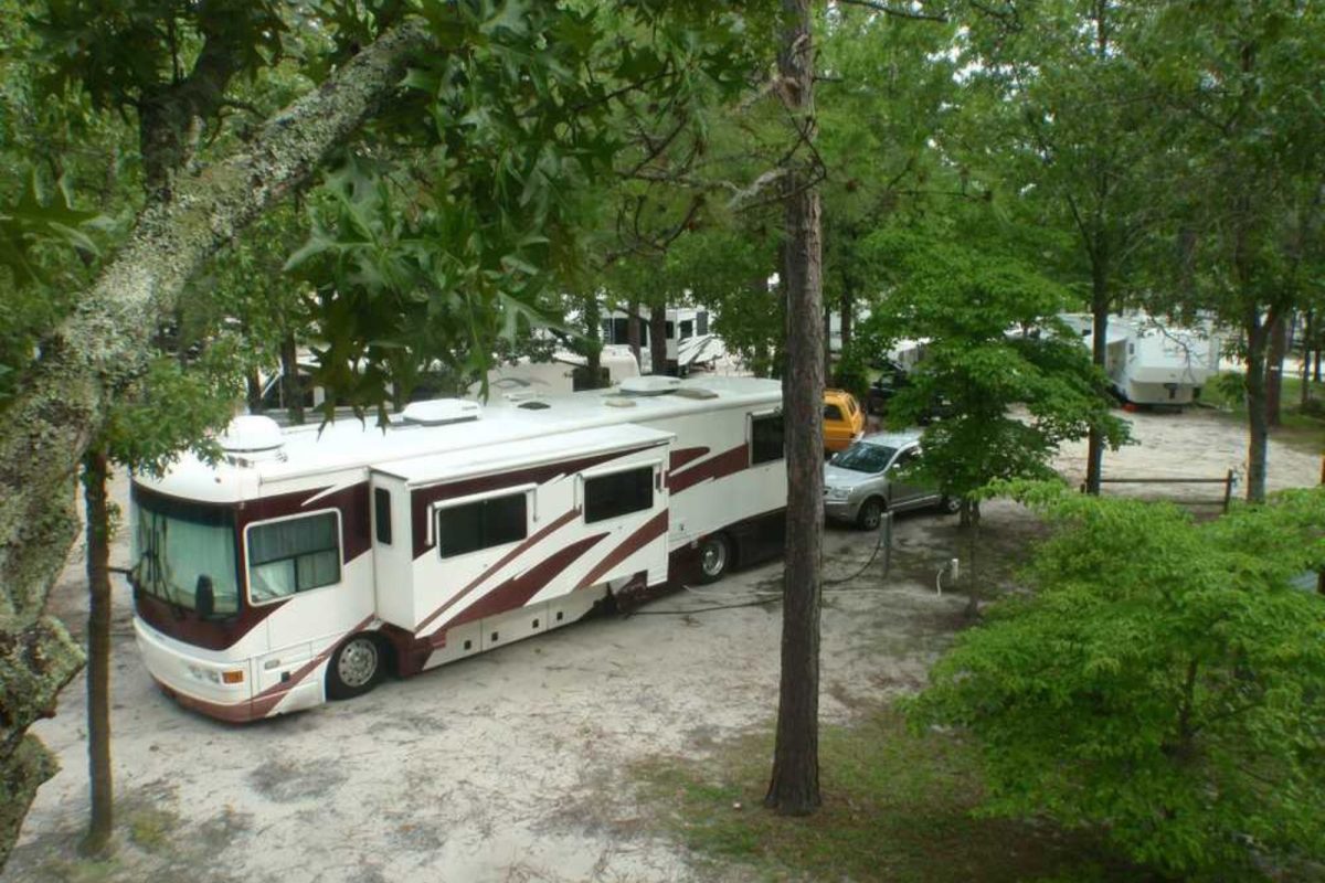 RV parked under green trees at North Carolina campground