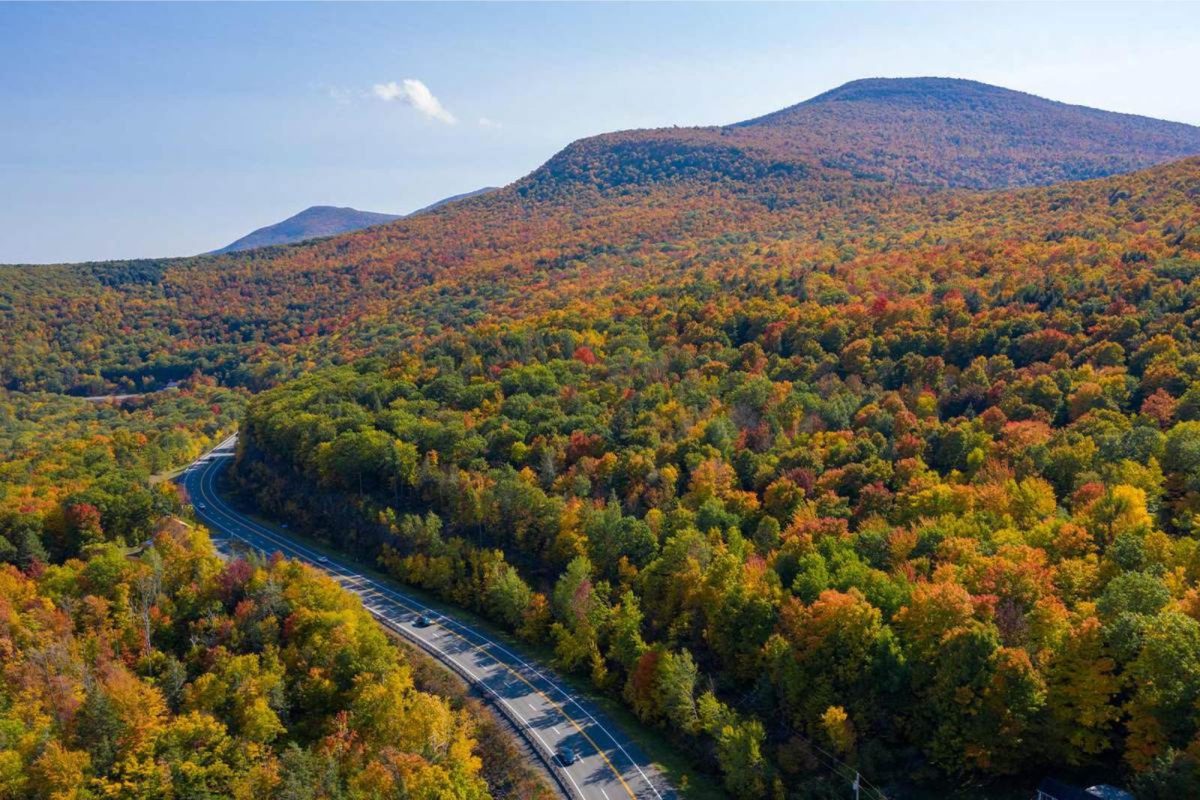 fall colors and car driving on road at Catskills