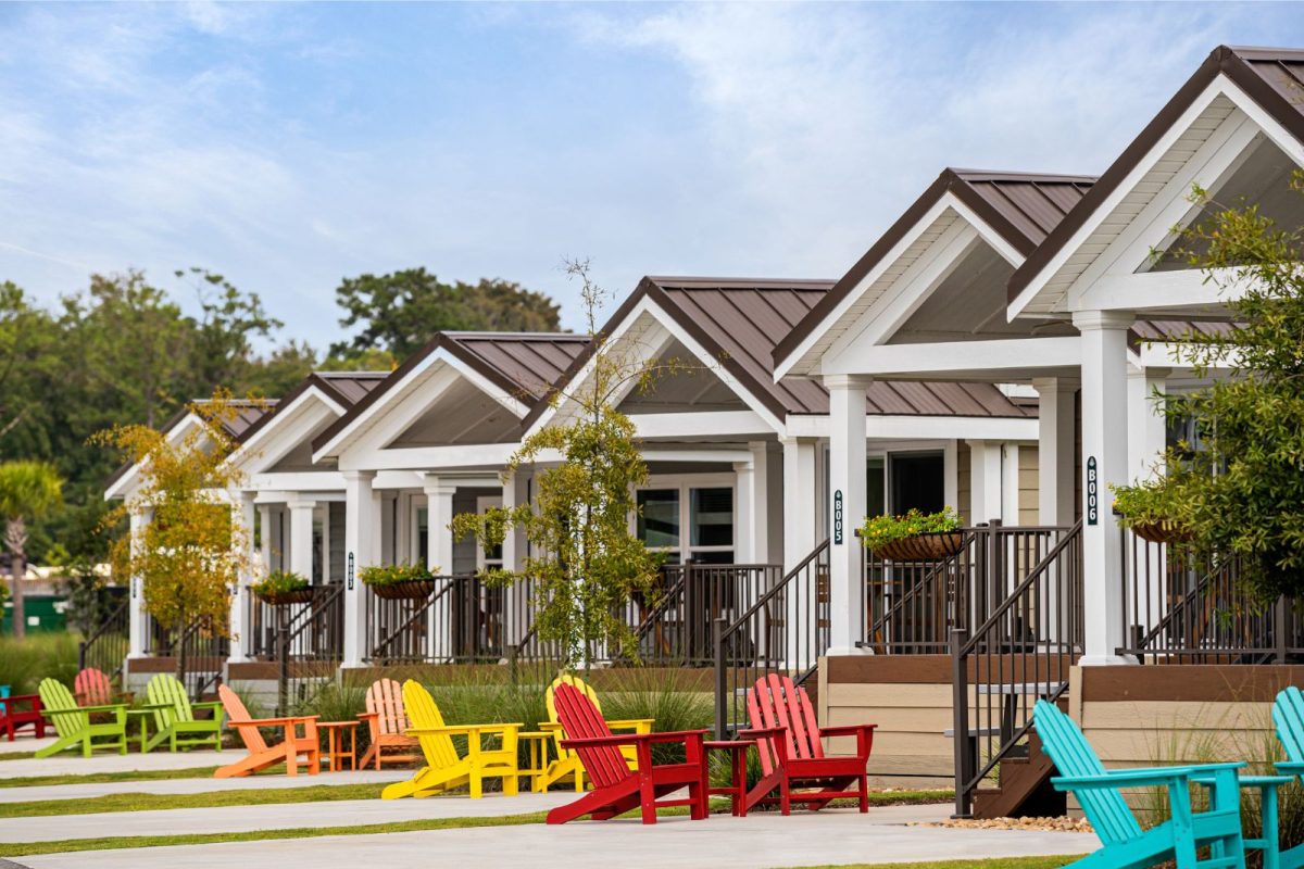 row of cottages, porches, and colorful lounge chairs at Carolina Pines RV Resor