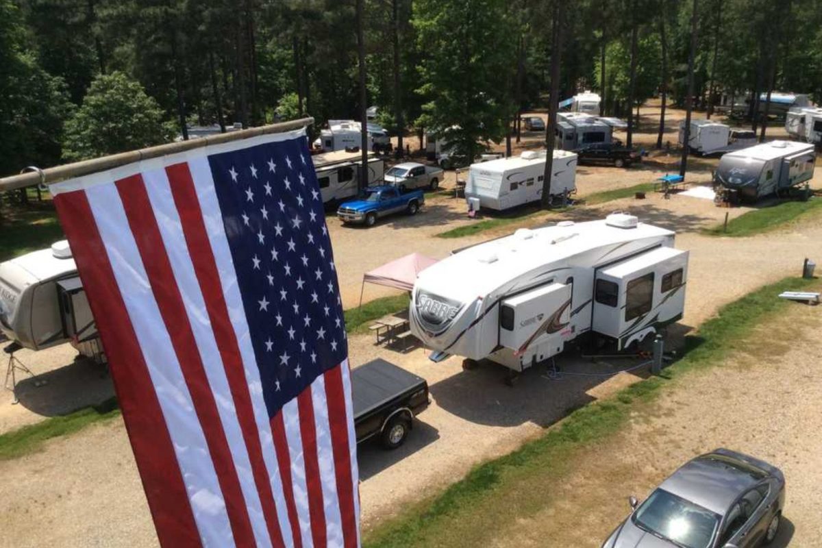 American flag hanging over parked RVs and car at Winston-Salem campground