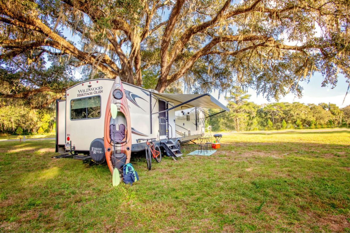 RV with kayak parked on field at a top spring break camping destination